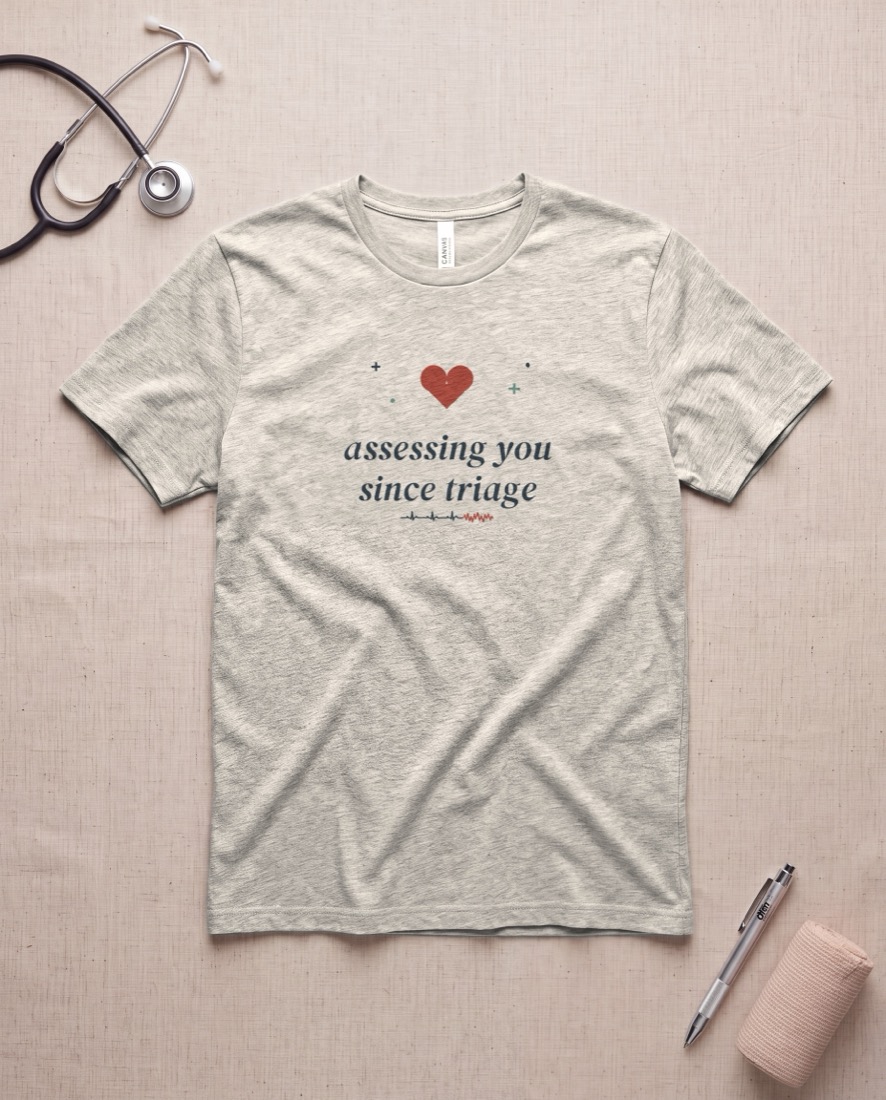Assessing You Since Triage tee, flat lay on a styled celestial surface
