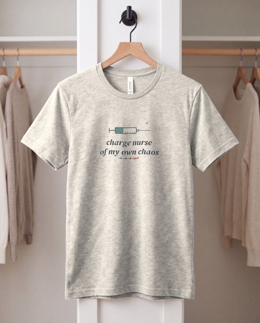 Charge Nurse Of My Own Chaos tee, hanging on a peg rail