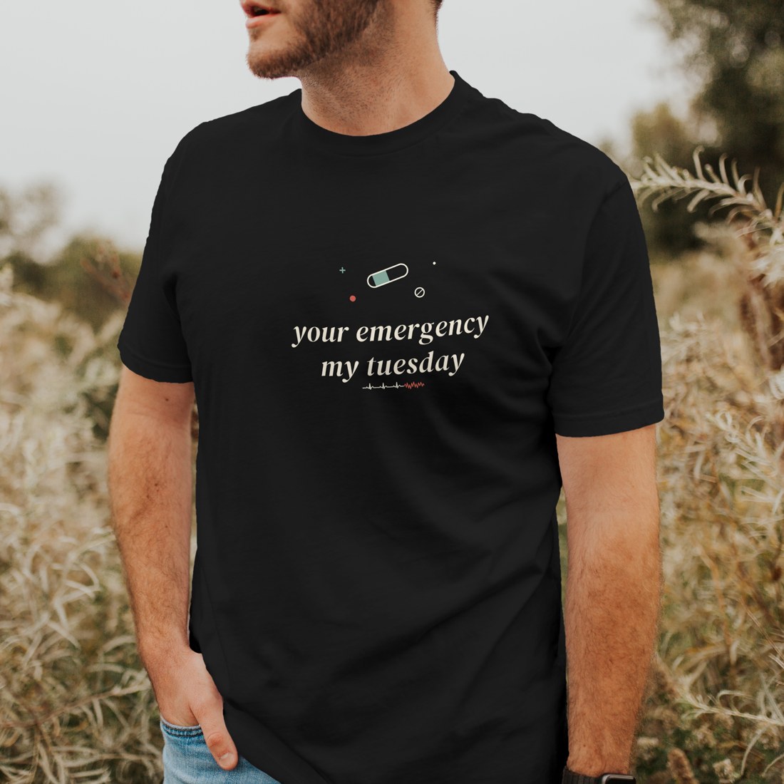 Vintage Black tee reading “your emergency, my tuesday” in a clean folded corner shot